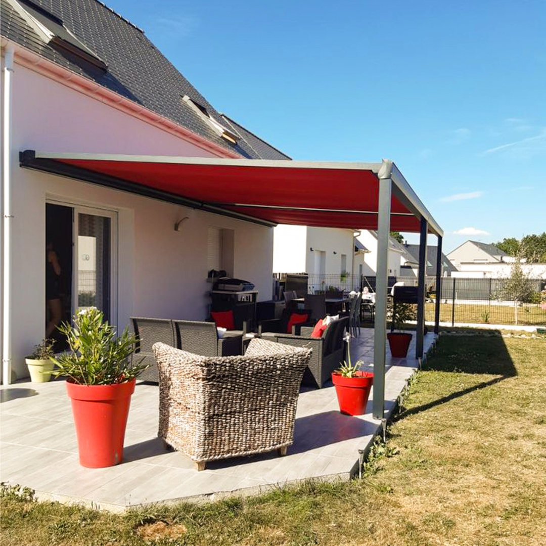 Pergola adossée à une maison avec toile d'ombrage rétractable rouge bordeaux