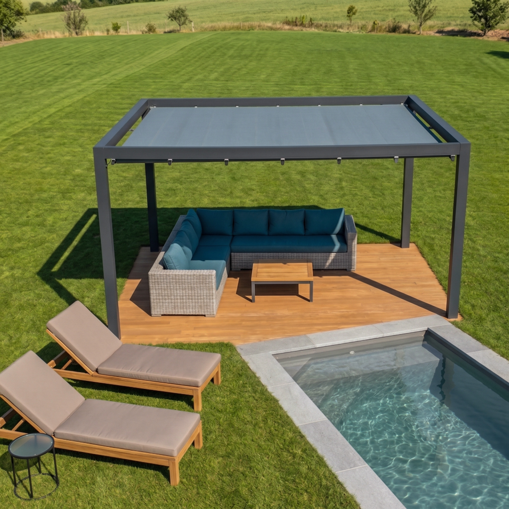 Pergola bioclimatique grise avec salon de jardin en résine tressée et transats en bois au bord d'une piscine creusée sur une pelouse.