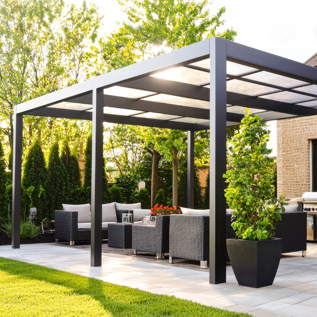 Pergola bioclimatique de luxe avec parois vitrées abritant un salon d'angle moderne et un espace repas donnant sur un grand jardin.